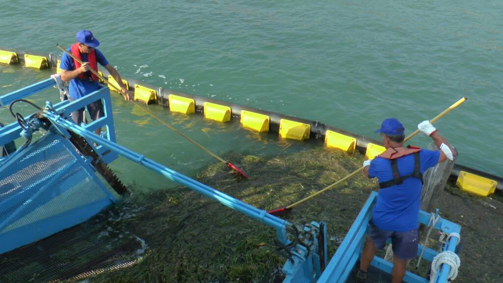 battello spazzino al lavoro sul lago d'Iseo